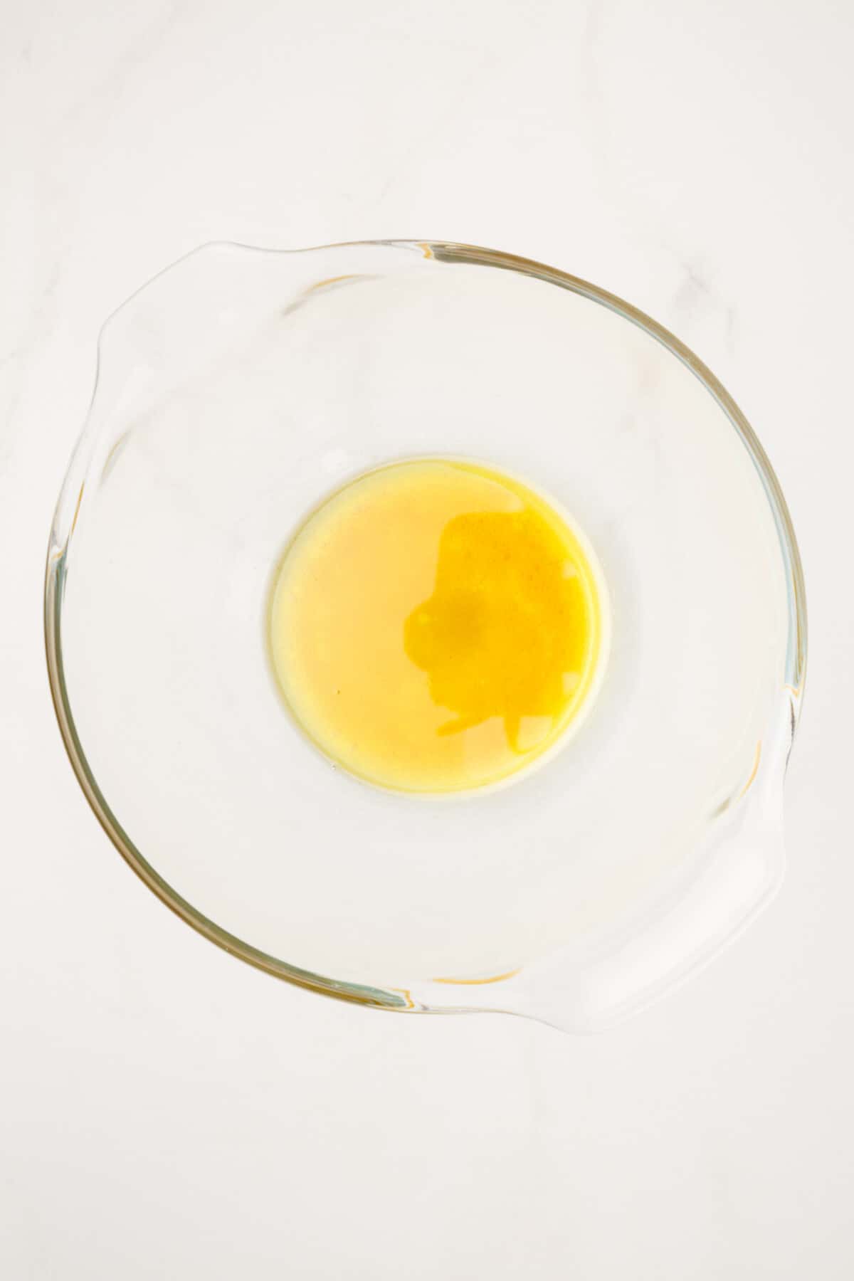 large glass mixing bowl of red wine vinegar dressing.