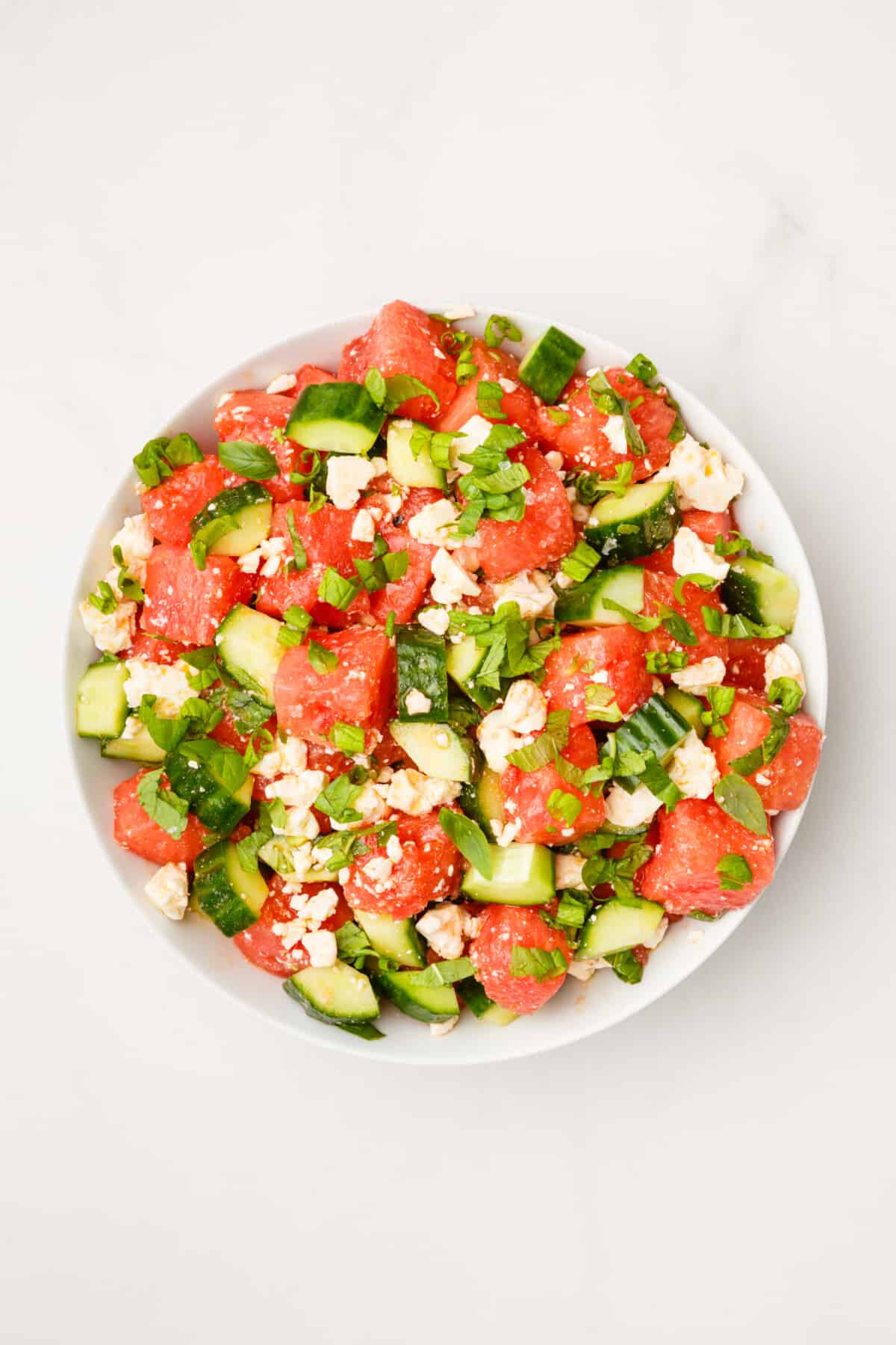 top down image of Watermelon and Feta Salad served on a white round plate.