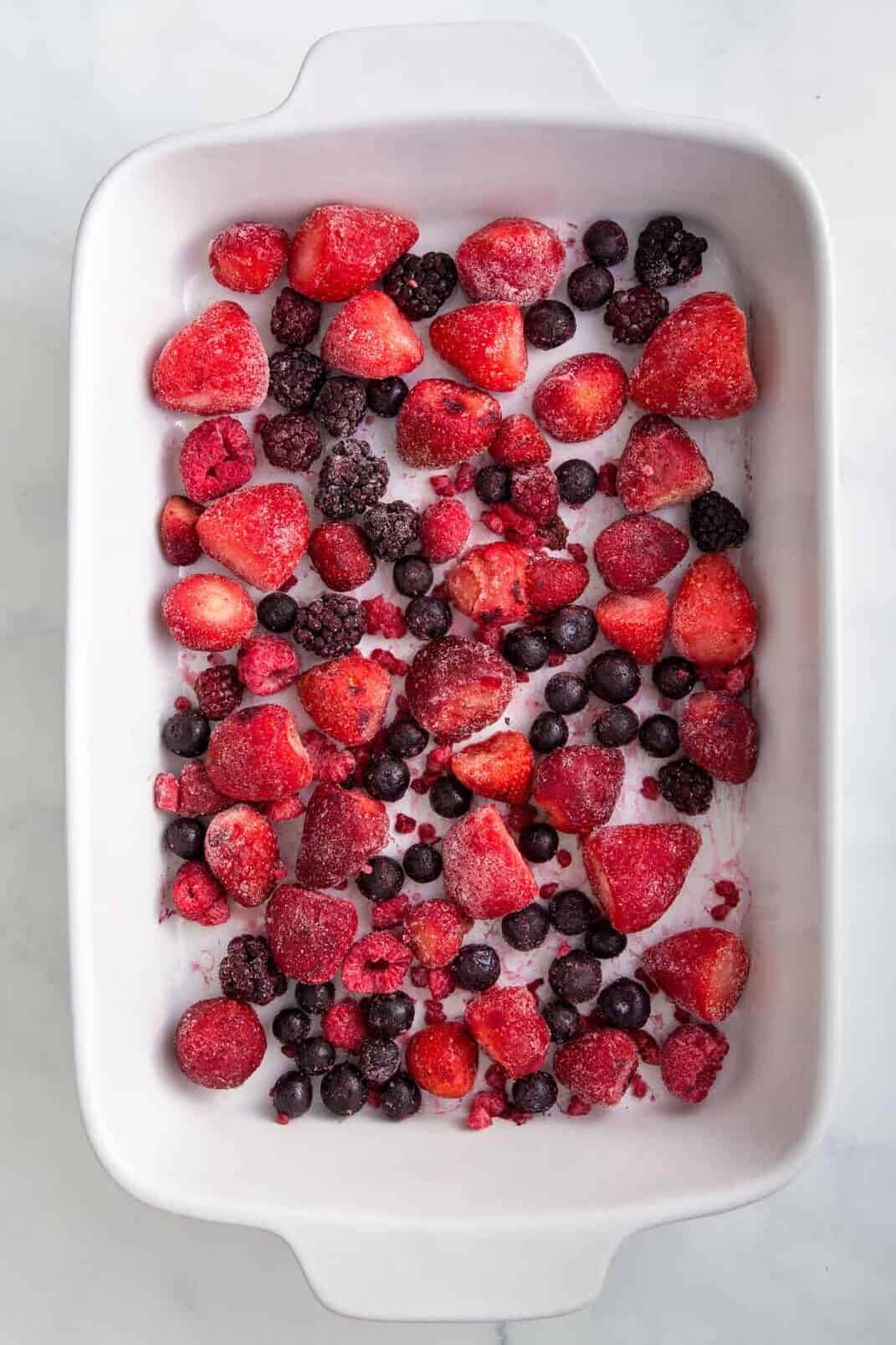 9x13 casserole dish with frozen berries spread evenly at the bottom