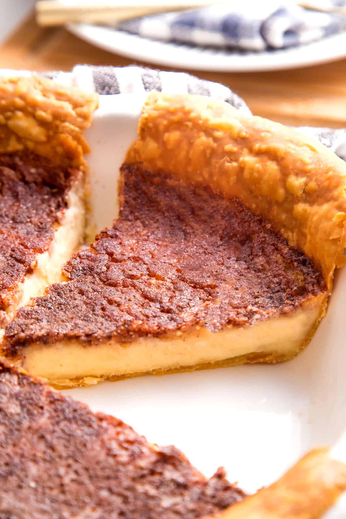 close up image of a slice of custard pie in a pie dish