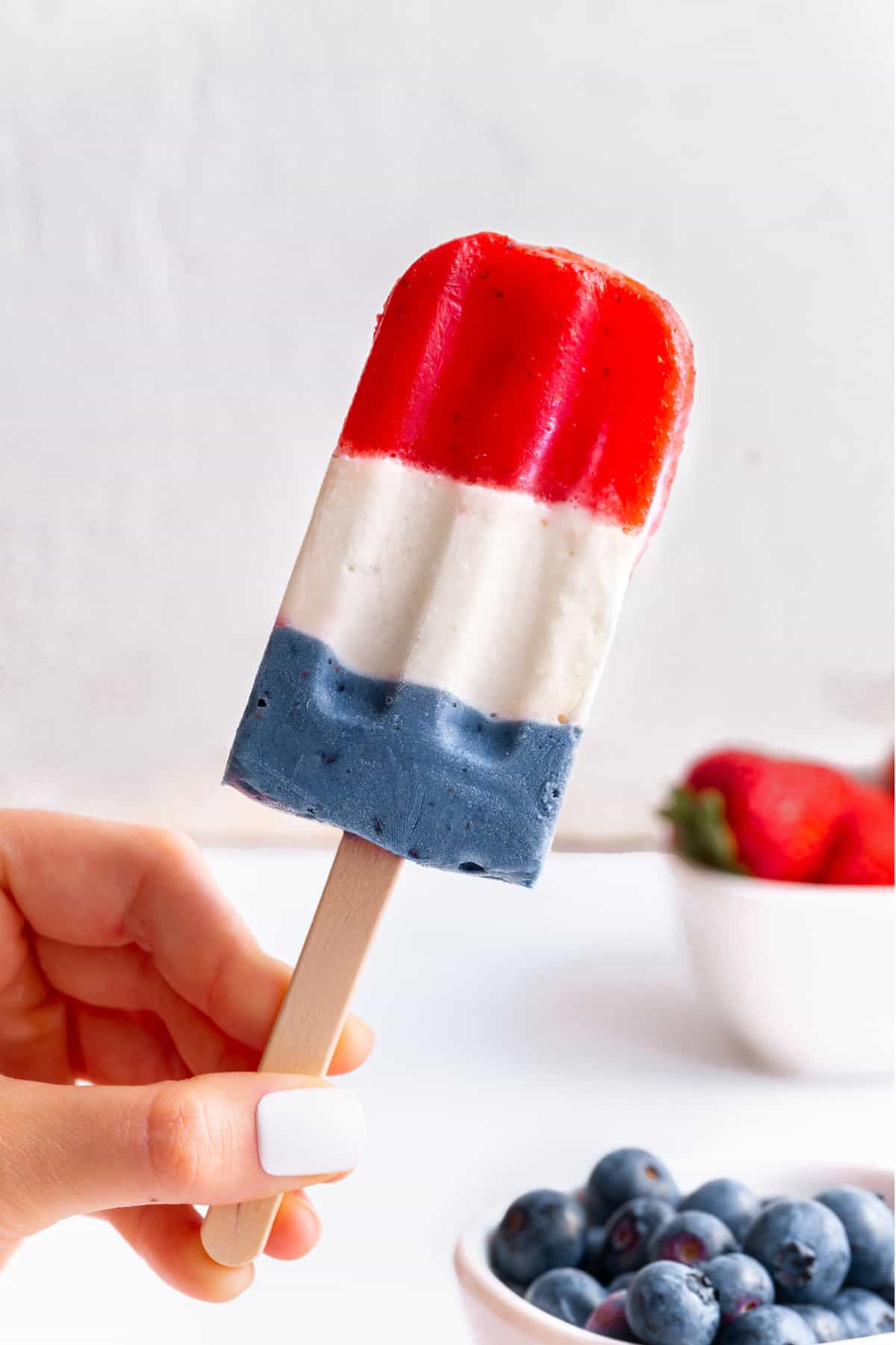 one red, white and blue layered popsicle on a stick