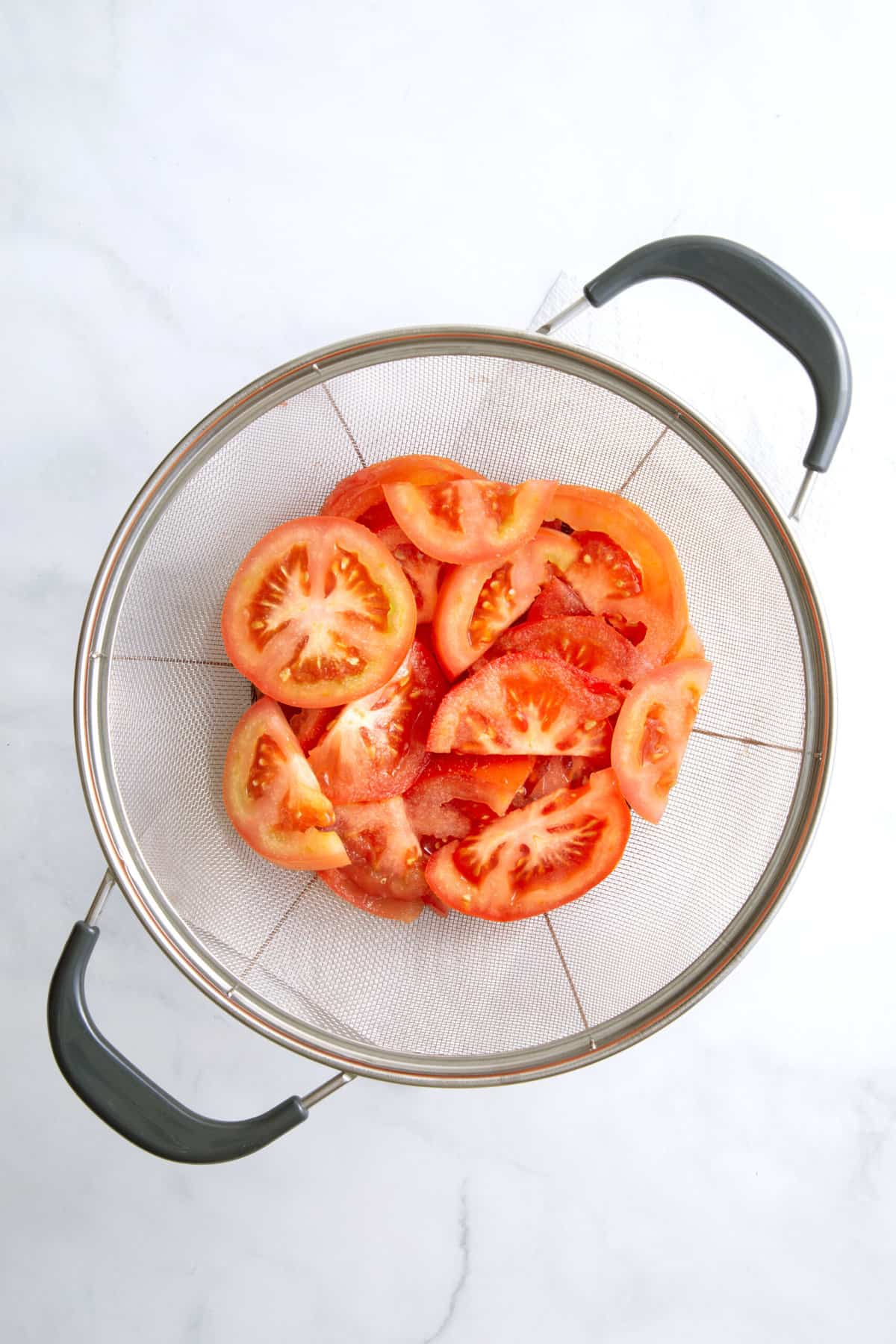 sliced fresh tomatoes in a sieve