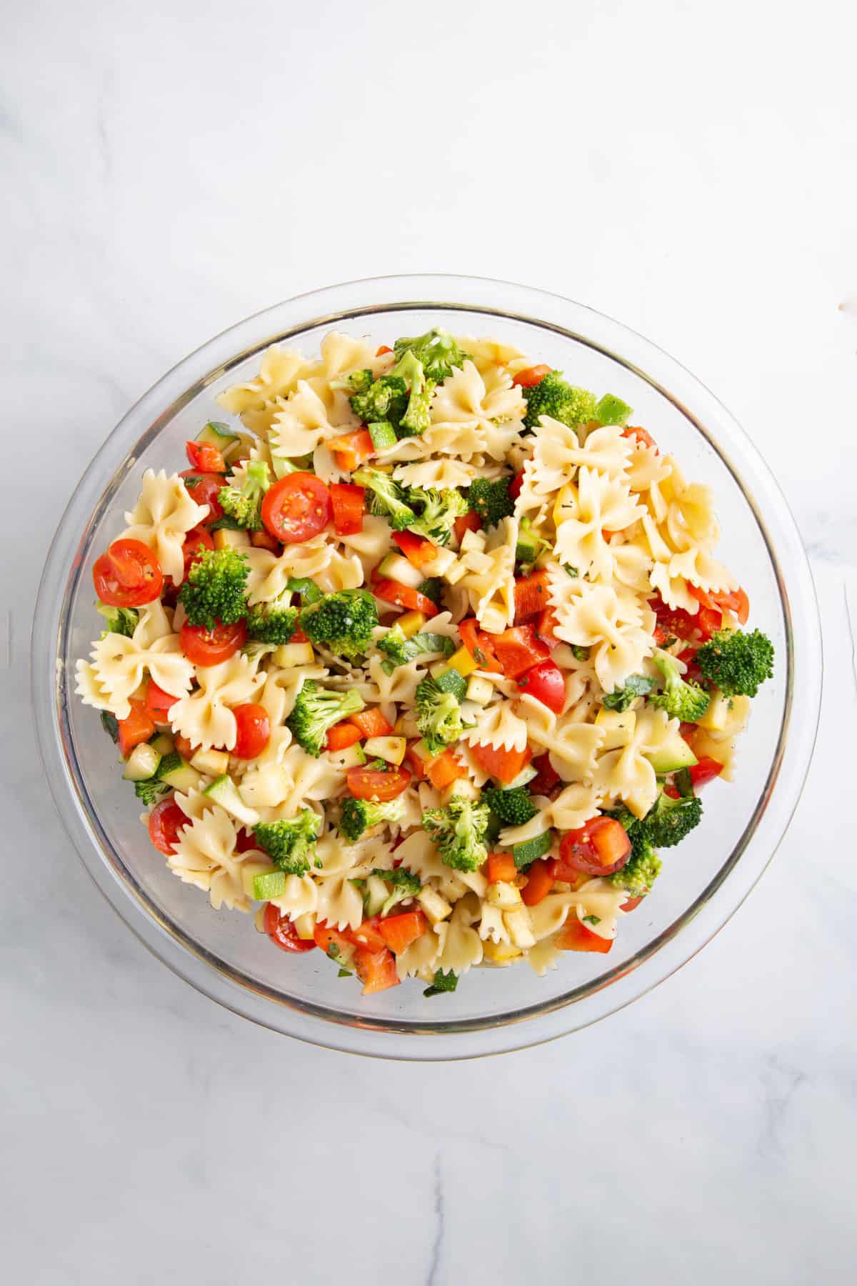 summer vegetable pasta salad in a large glass bowl