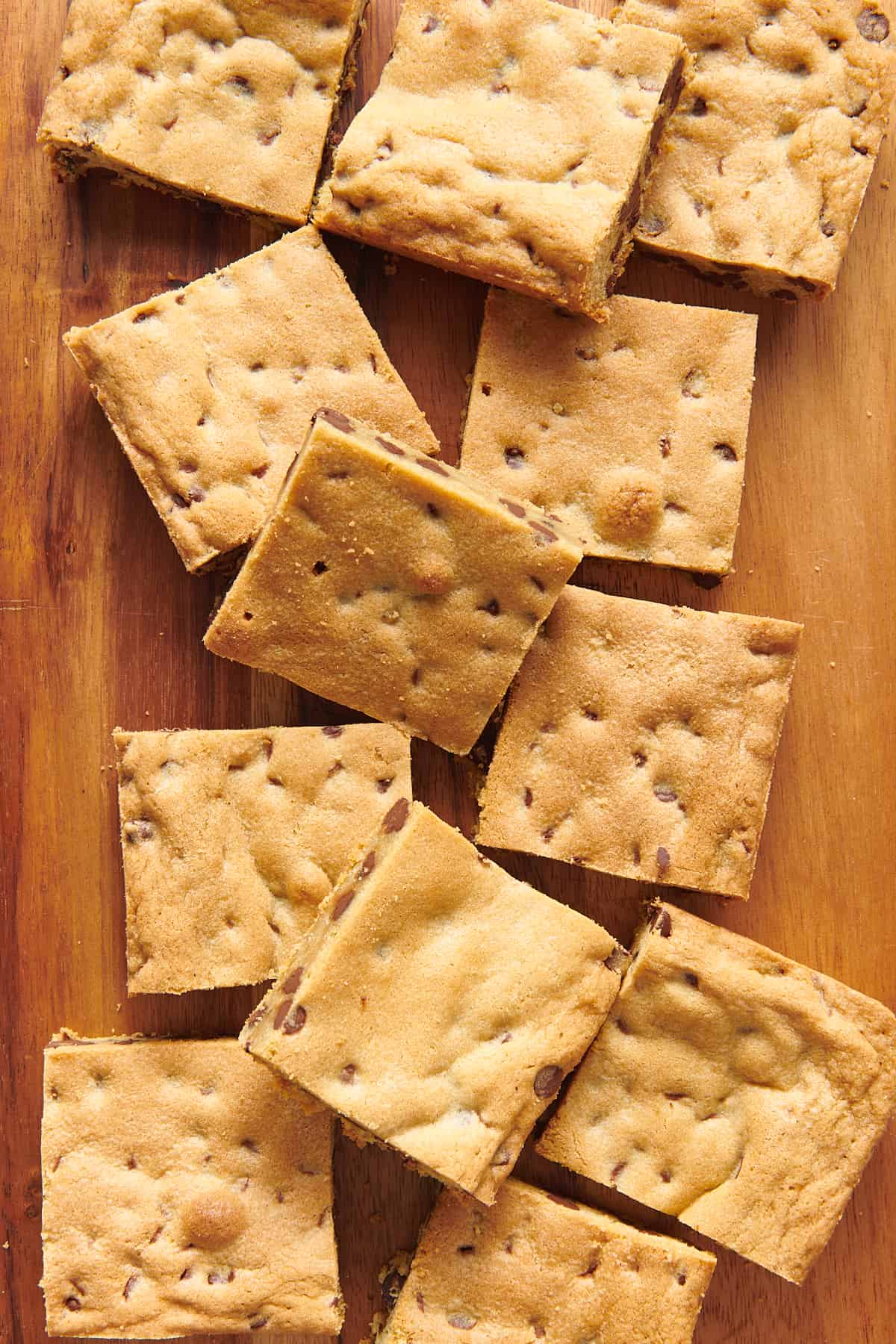 top down image of chocolate chip cookie bars sitting on a wooden board