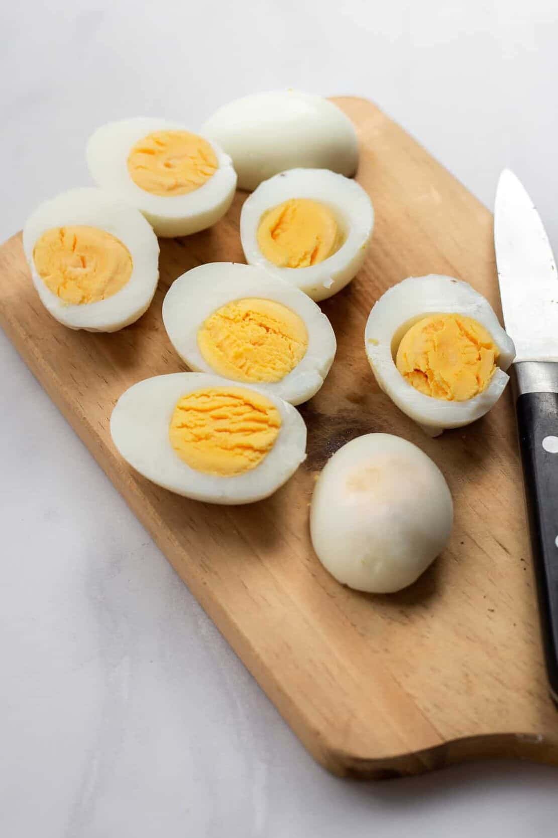 4 hard boiled eggs cut in half longways sitting on a wood cutting board
