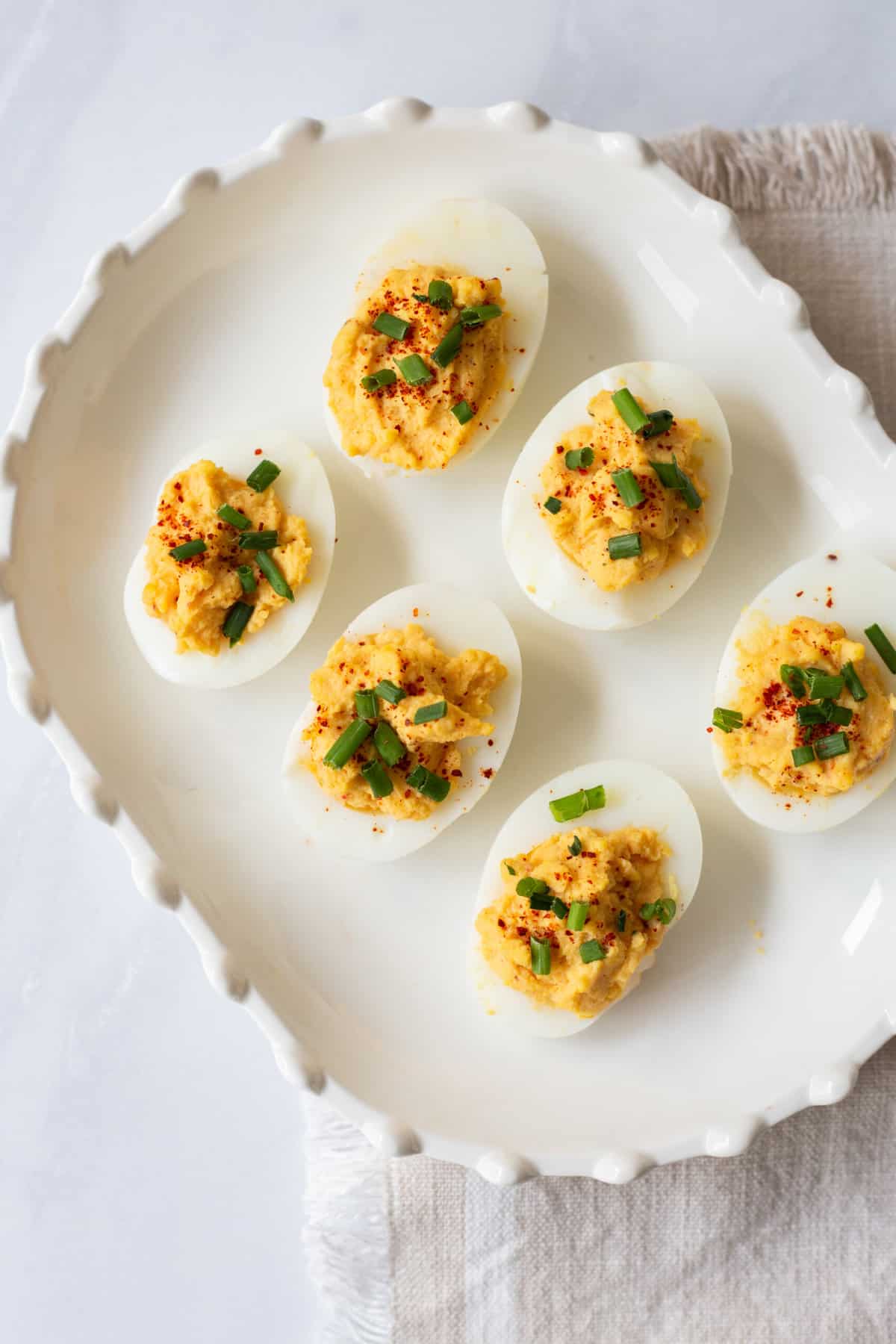 top down image of a white decorative plate with prepared deviled eggs