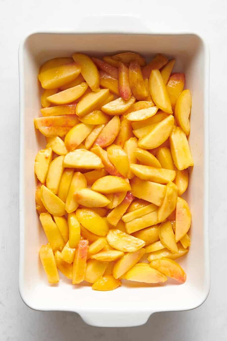 9x13 casserole dish filled with sliced peaches