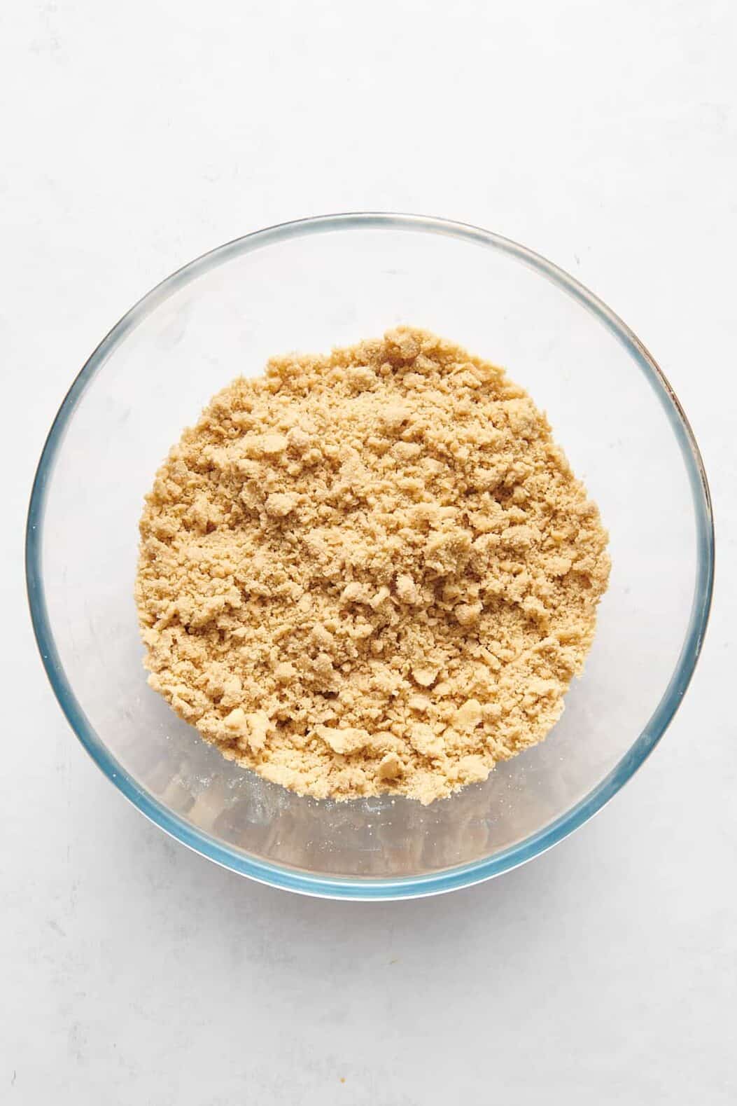 large glass bowl of peach crumble topping mixture