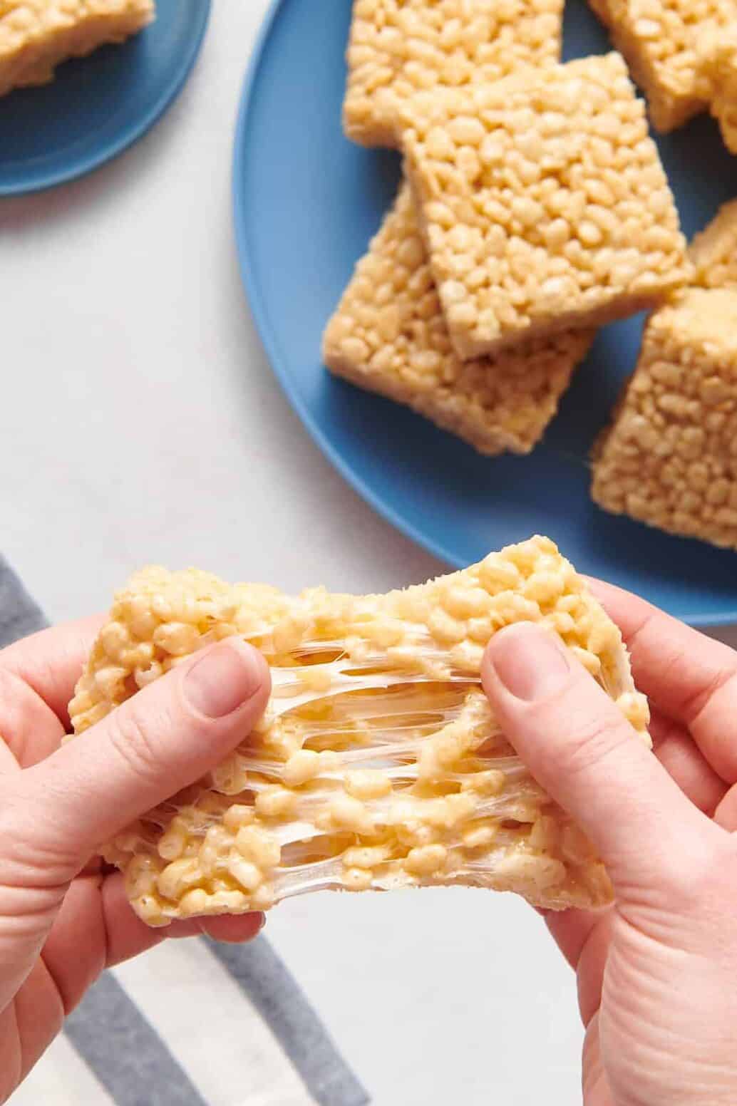 hands pulling and stretching a rice krispie treat