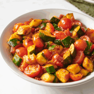A bowl of sautéed zucchini and tomatoes.