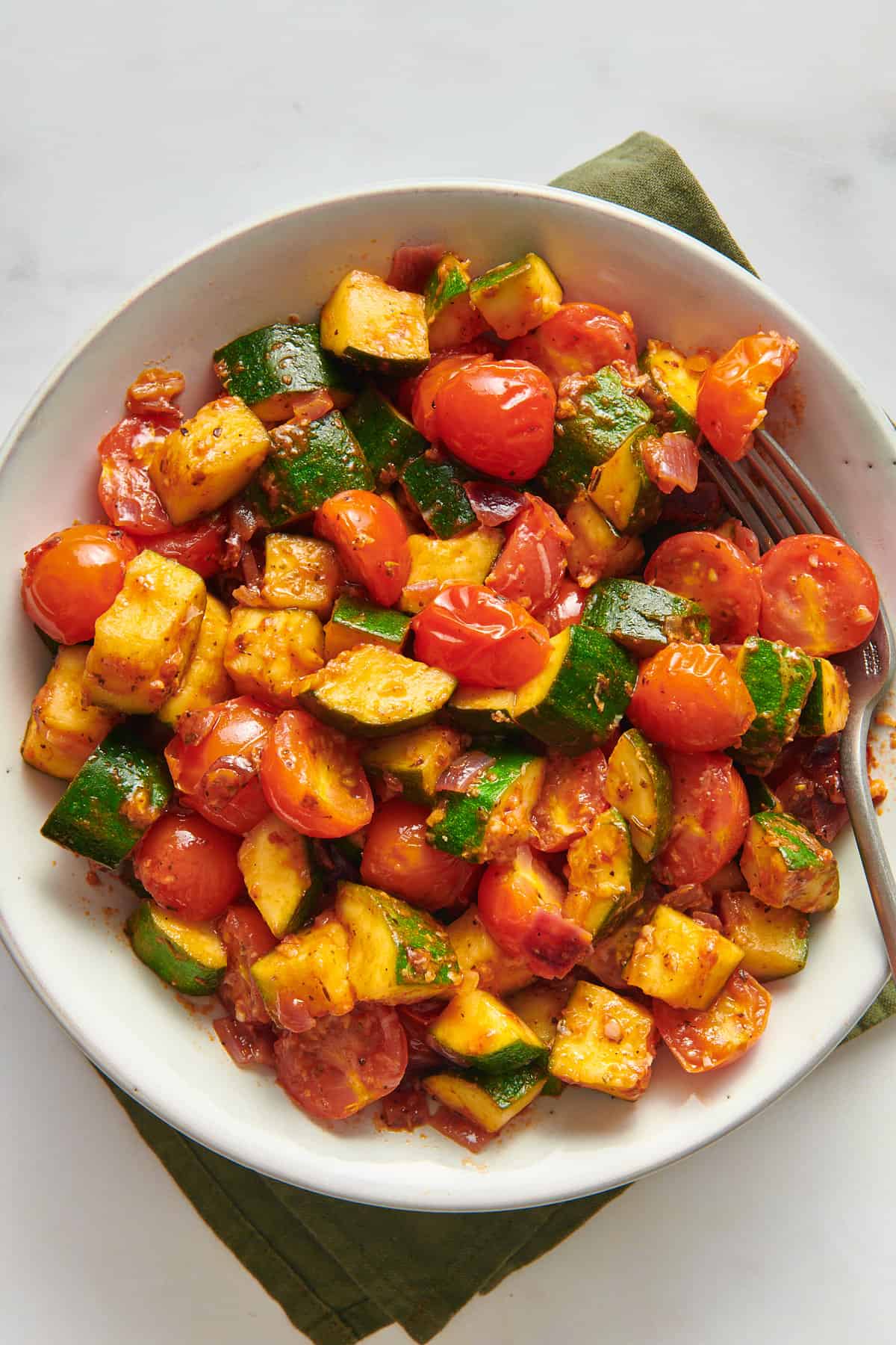 top down image of sauteed zucchinis and tomatoes