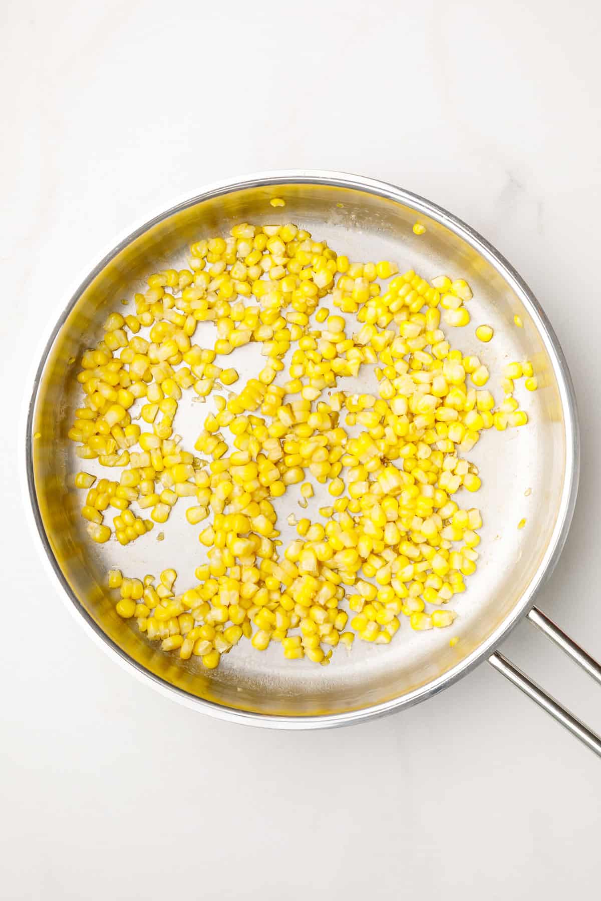 corn kernels sitting in a stainless steel pan