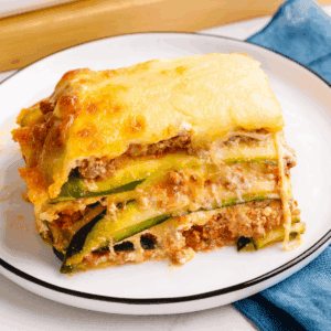 A square slice of zucchini lasagna on a plate.