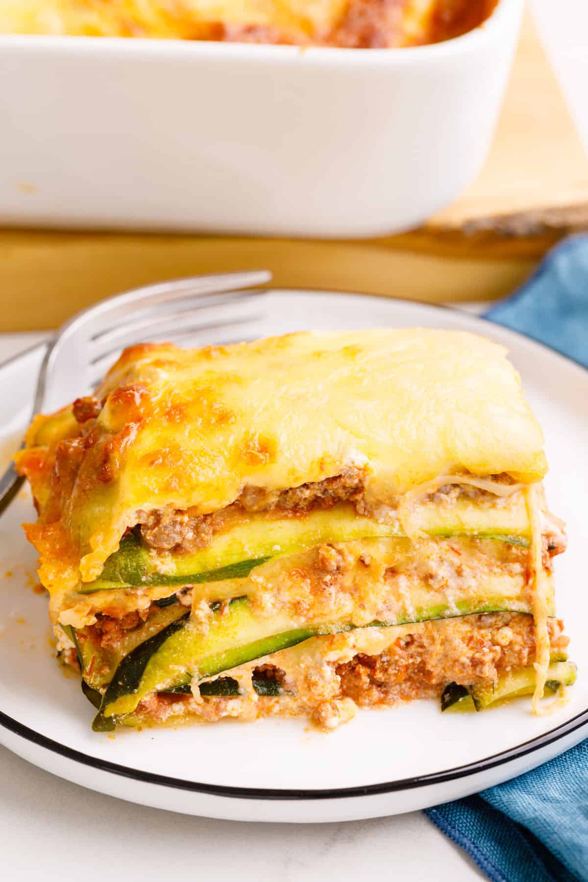 serving of zucchini lasagna sitting on a white round plate