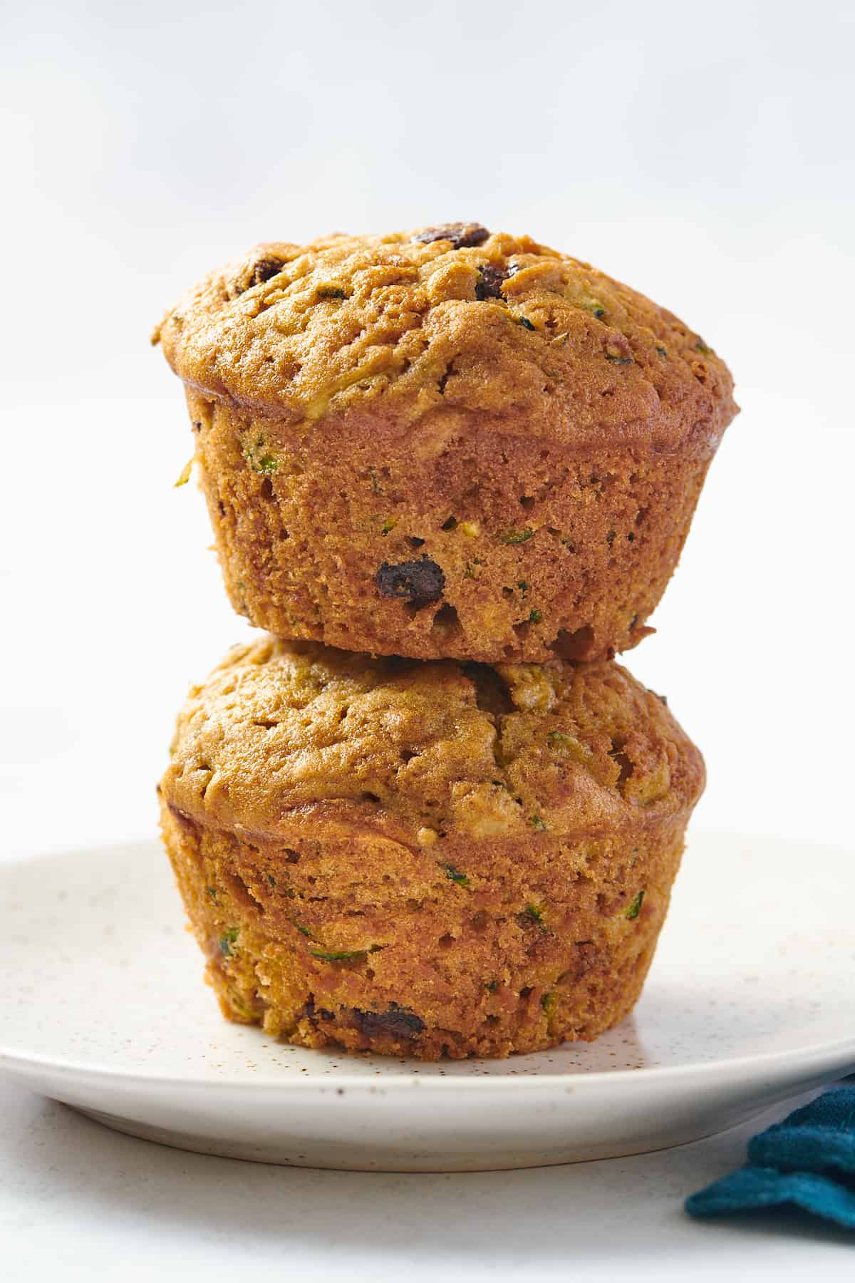 stack of two zucchini muffins sitting on a speckled plate