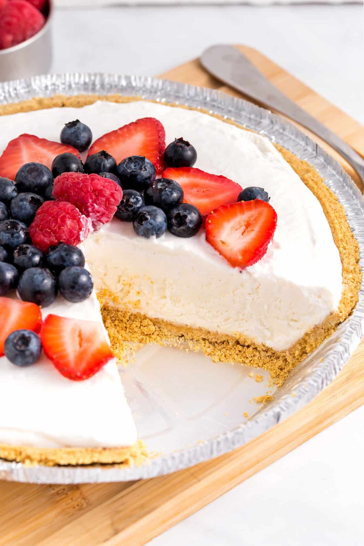 close up image of the cross section of cool whip pie topped with fresh berries
