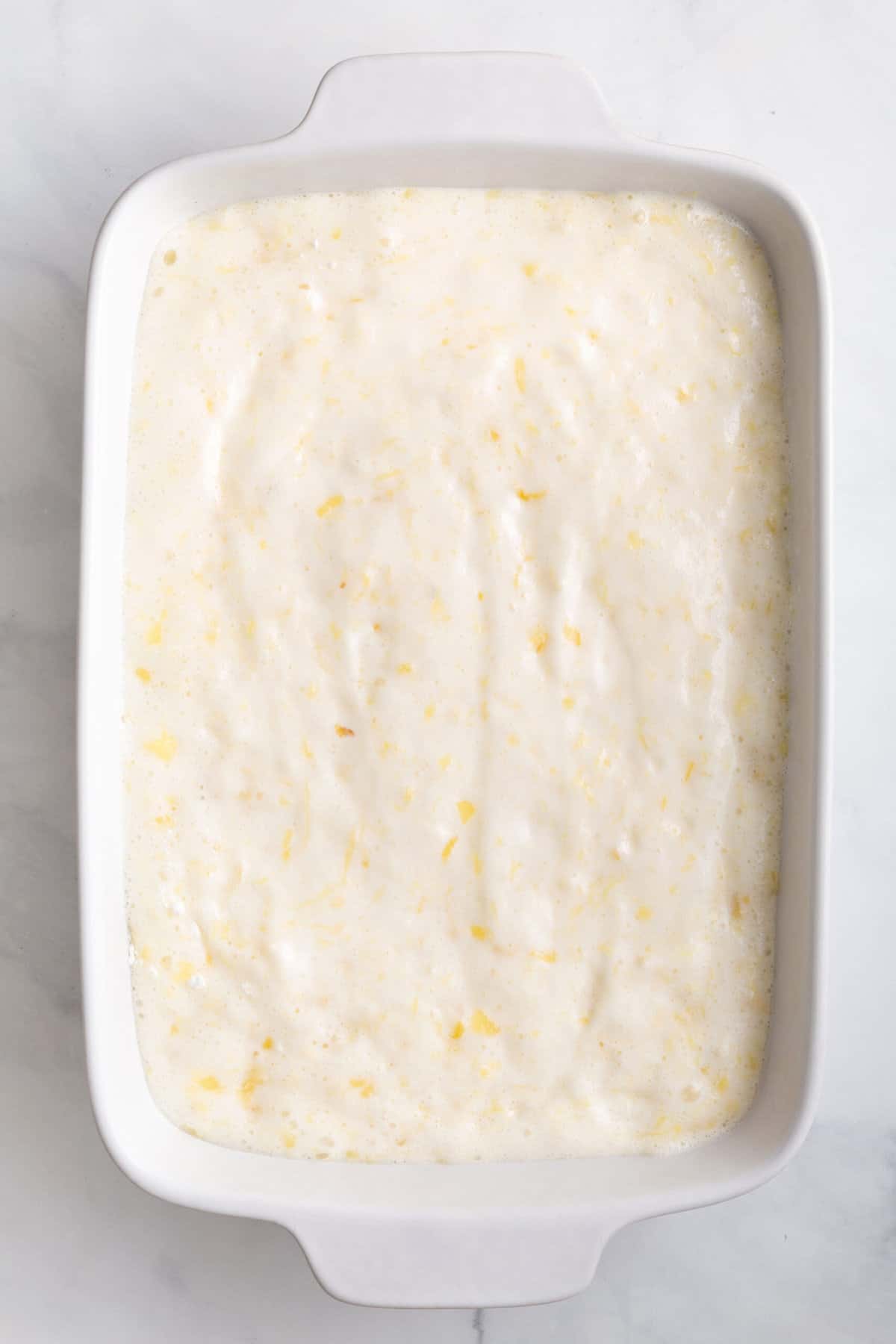 pineapple angel food cake batter sitting in a 9x13 baking dish