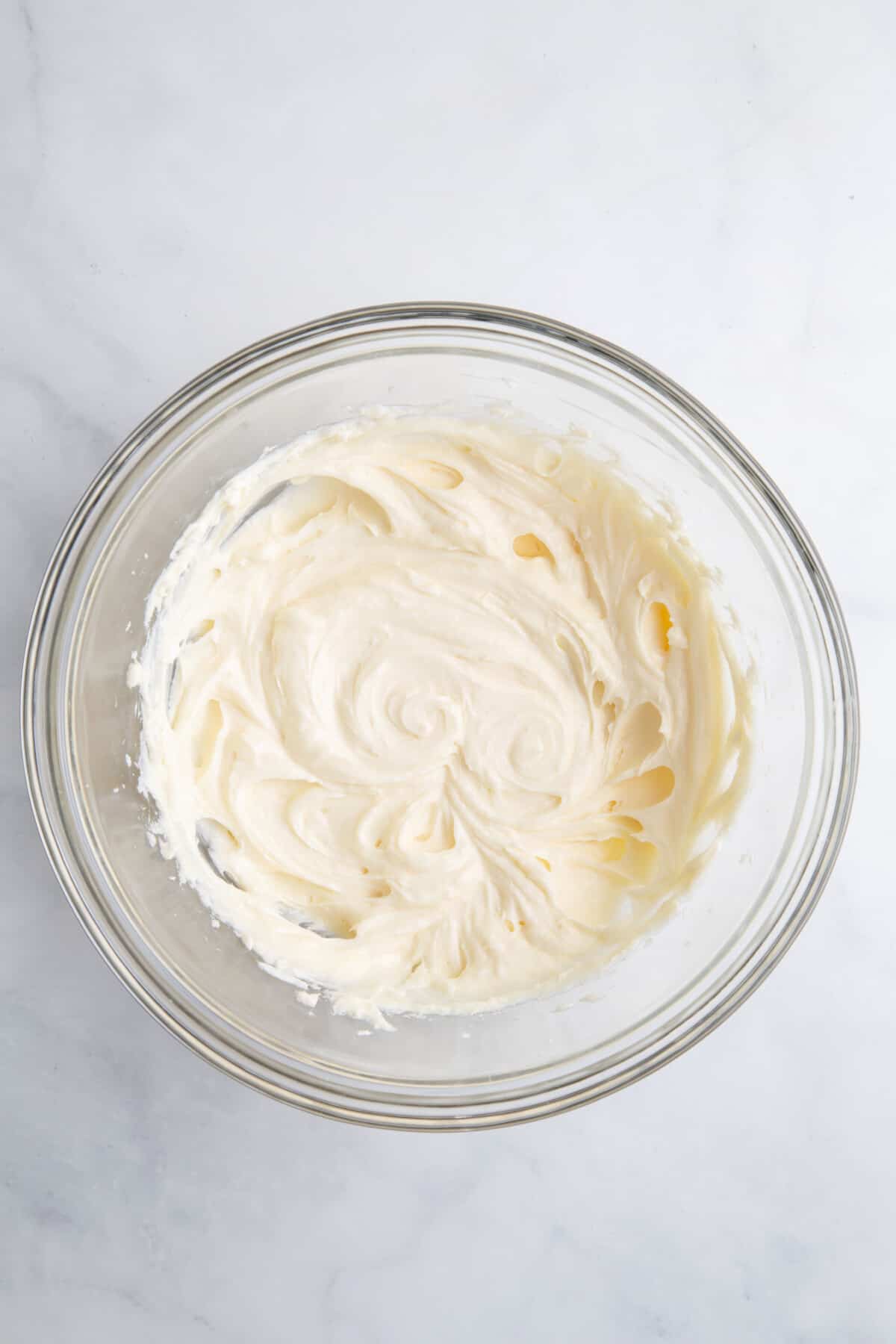 large glass bowl of cream cheese, sugar and vanilla extract whisked until light and fluffy.