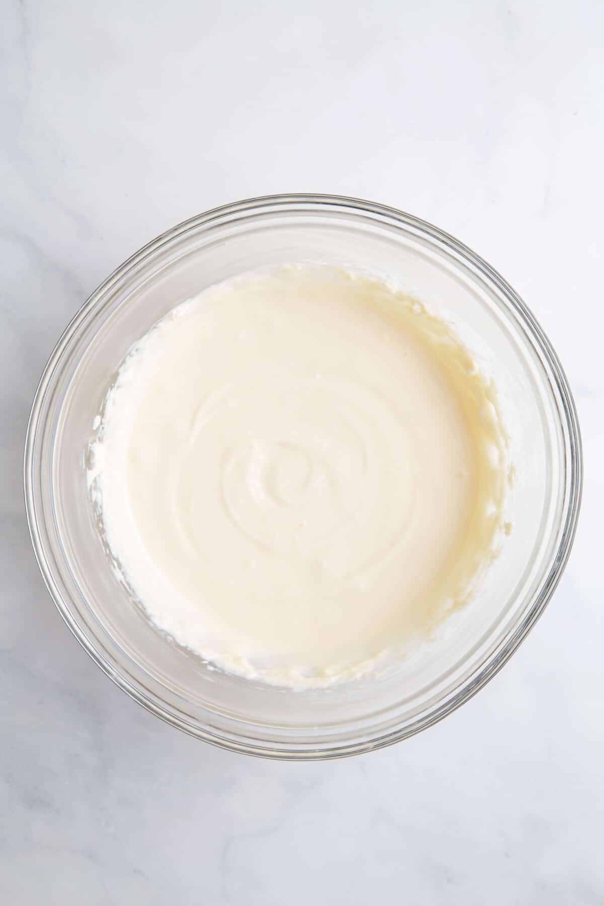 large glass bowl of cream cheese, sugar and vanilla extract, milk and cool whip whisked until light and fluffy.