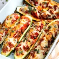A baking dish full of cheesy stuffed zucchini.
