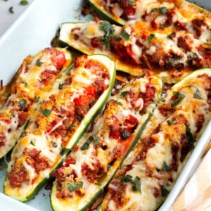 A baking dish full of cheesy stuffed zucchini.