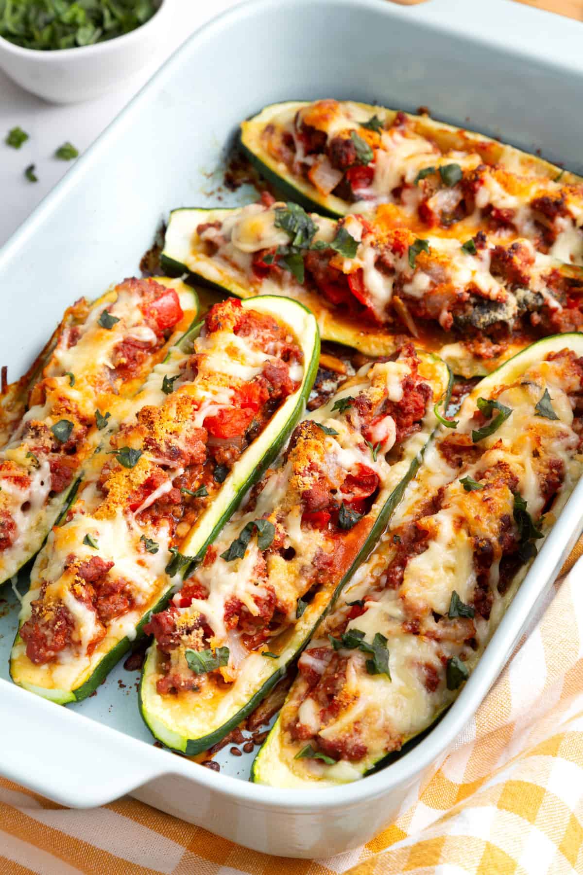 stuffed zucchini perfectly cooked and sitting in a blue 9x13 casserole dish