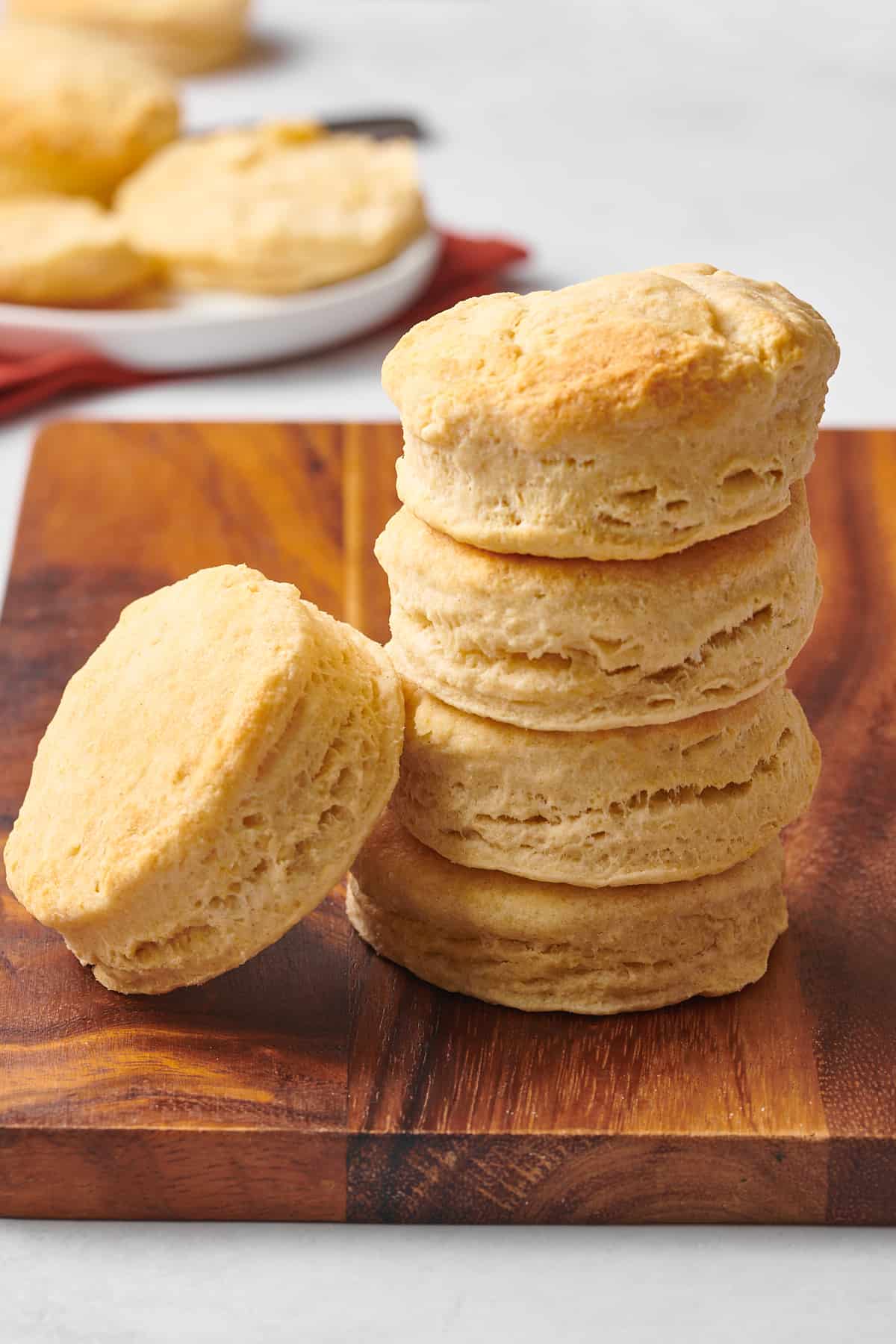 stack of four 7up biscuits with one leaning on the stack sitting on a wooden board