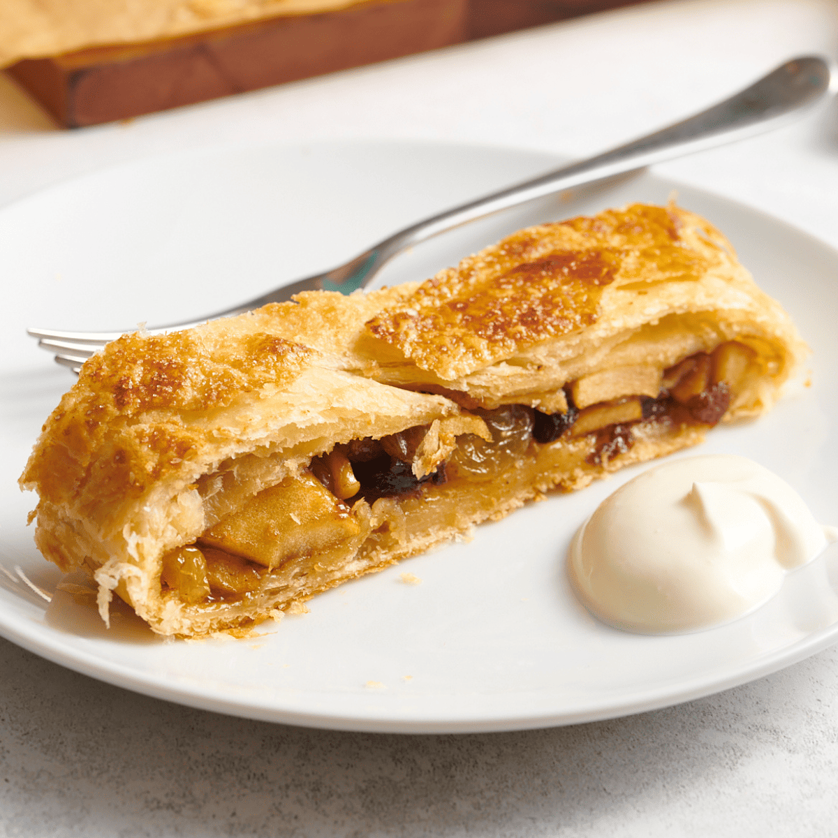 A slice of apple strudel on a plate.