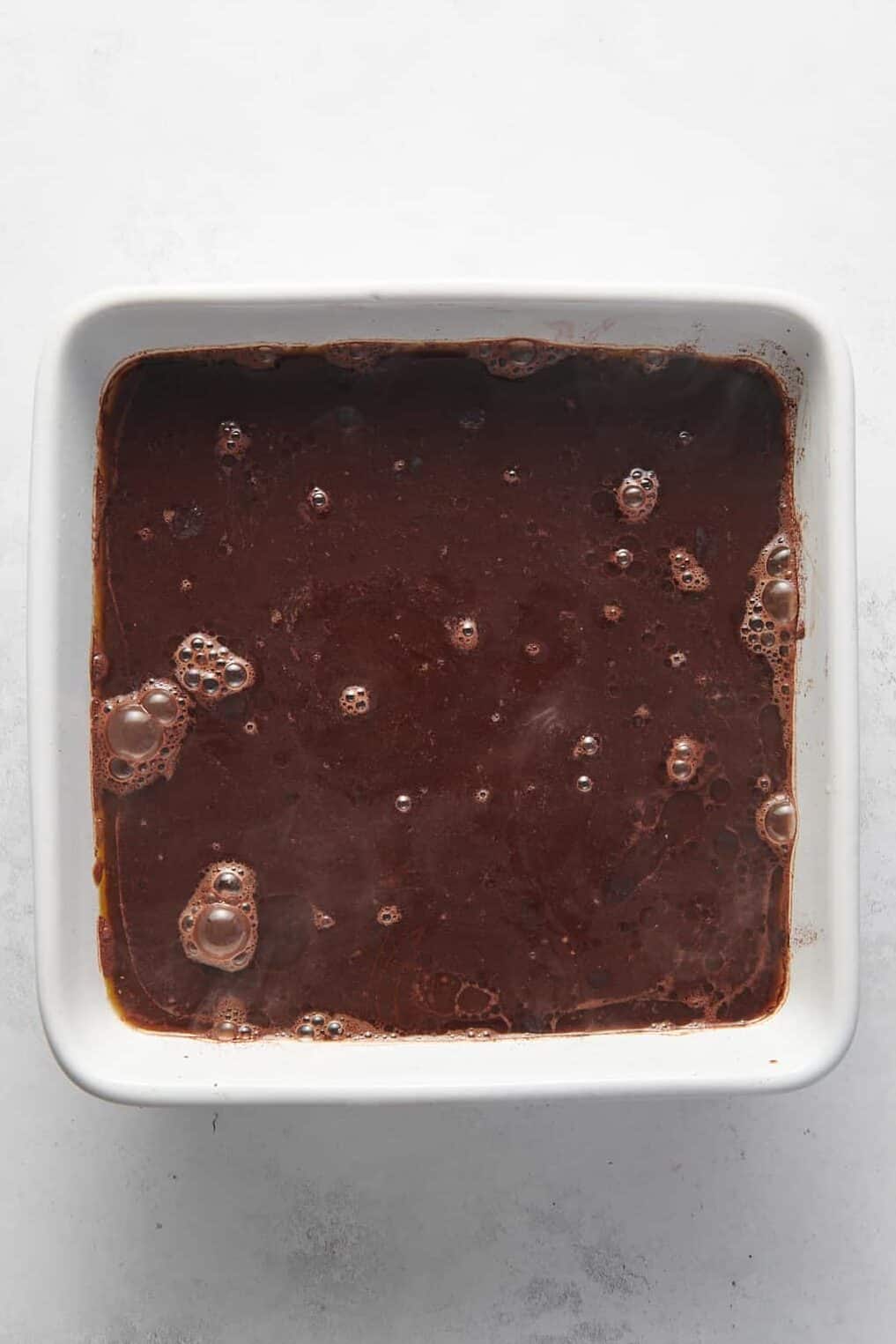 boiling water poured on top of the cocoa powder and sugar layered chocolate cake batter and melted butter mixture