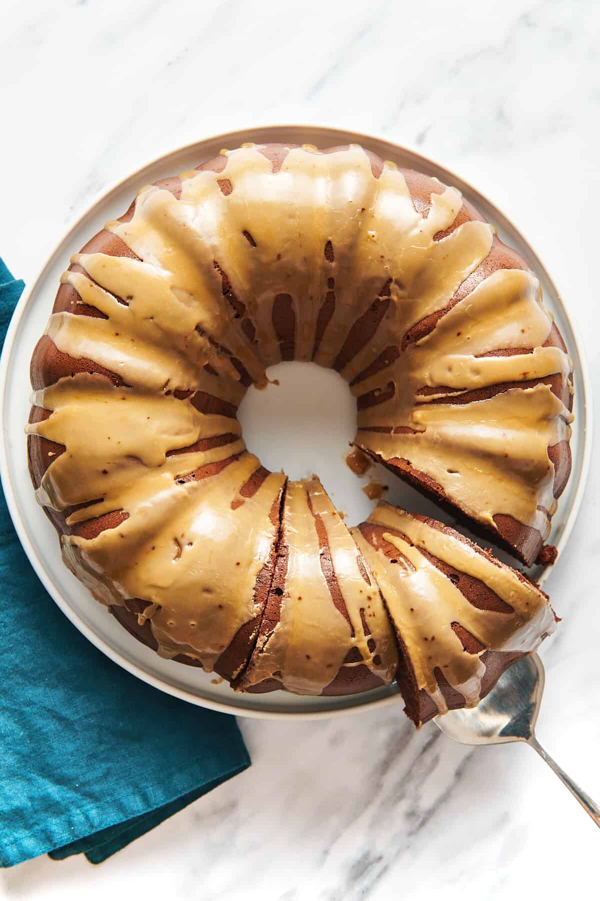 top down image of chocolate kahlua cake topped with glaze sitting on a white round plate