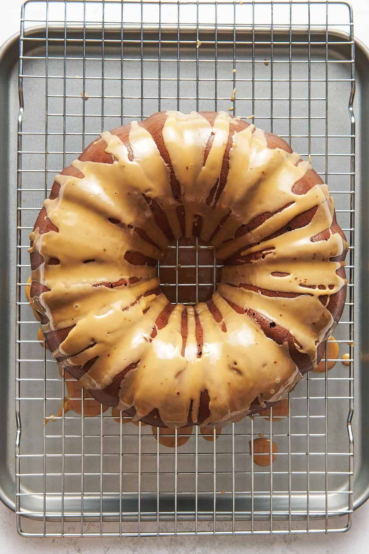 chocolate kahlua bundt cake topped with glaze sitting on a wire cooling rack