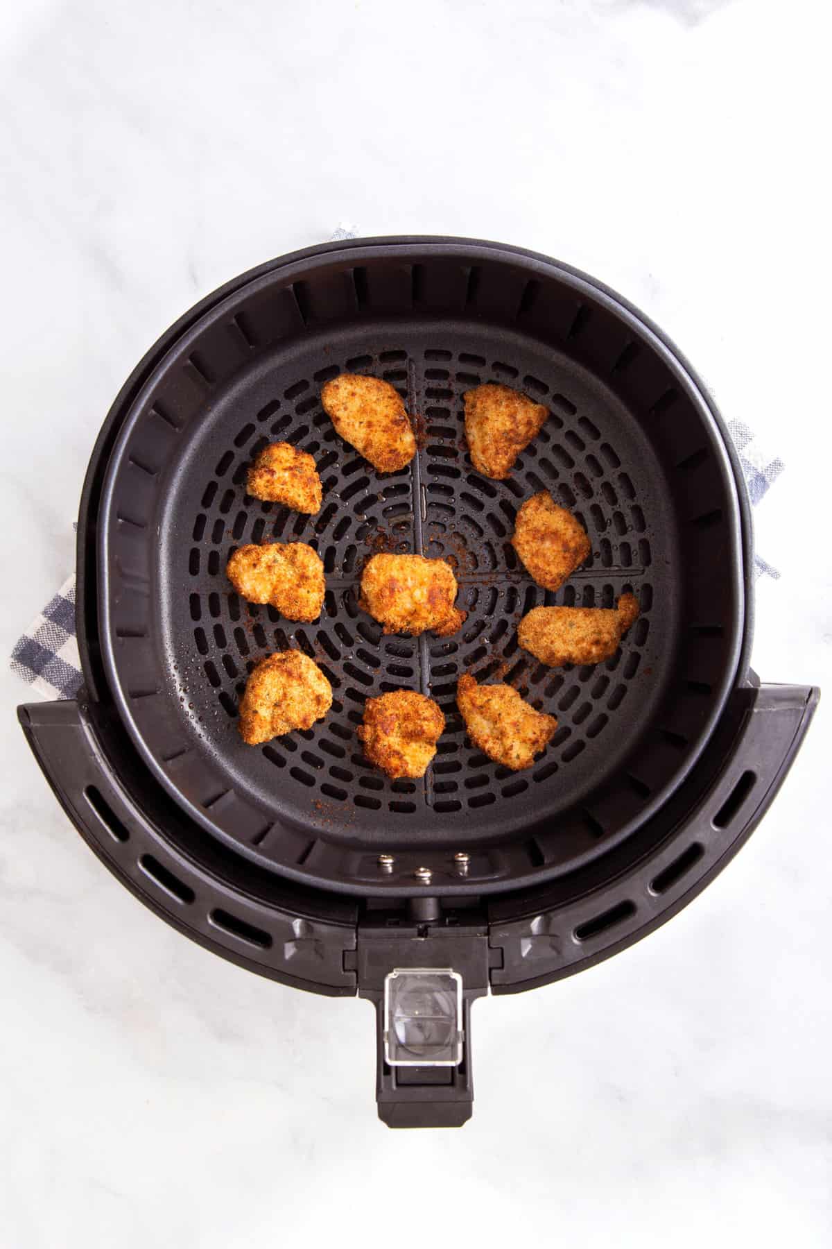 cooked chicken nuggets sitting in an air fryer
