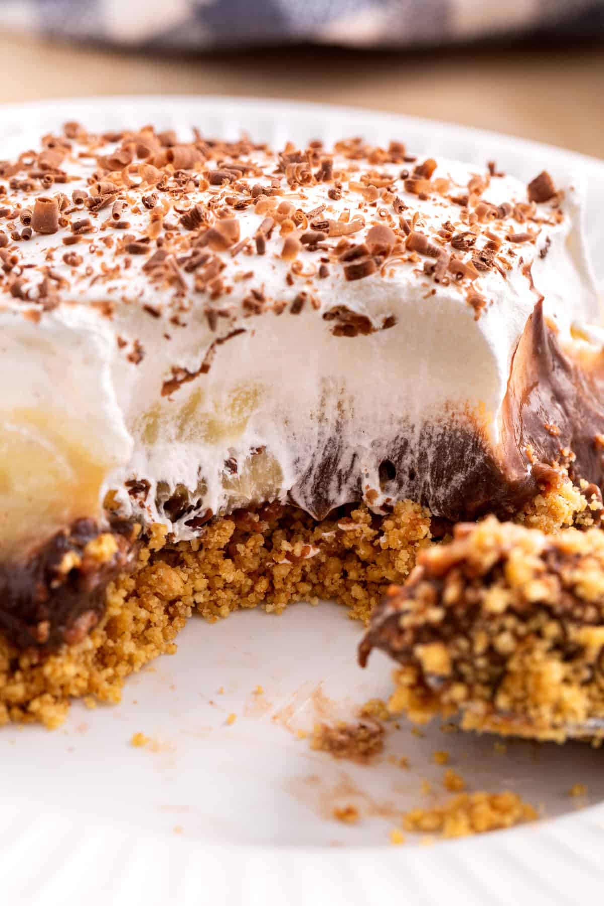 close up image of the cross section of a chocolate banana pudding bar sitting on a white round plate