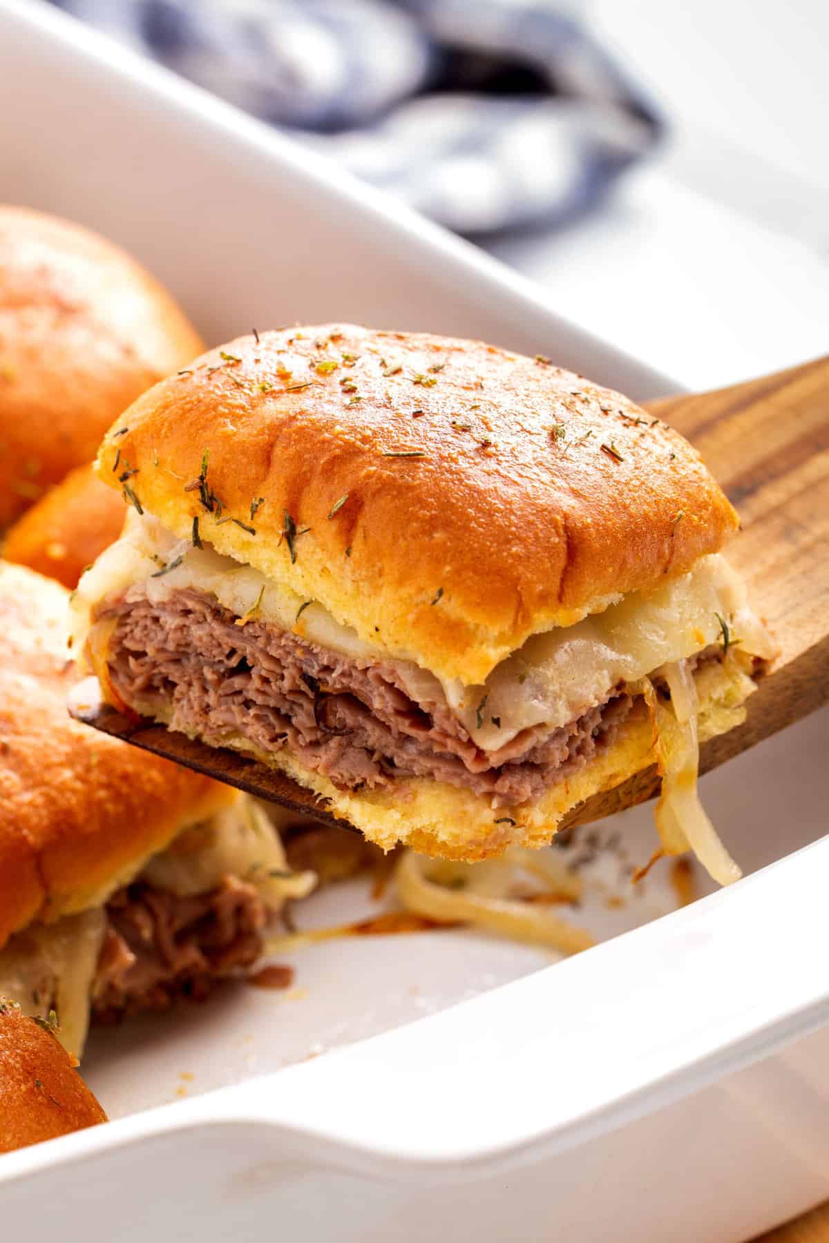 close up image of a french dip slider sitting on a wood spatula
