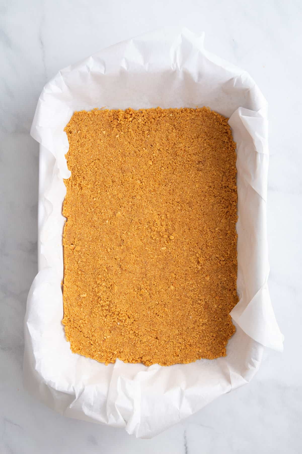 graham cracker crust pressed into a parchment paper lined 9x13 baking dish