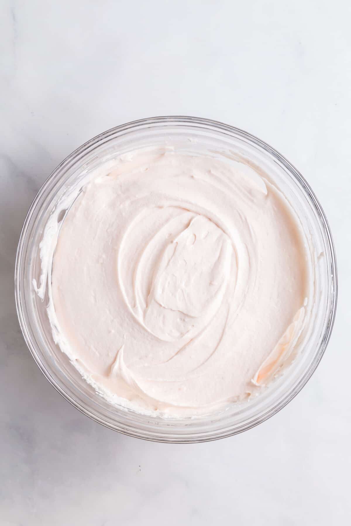 cool whip, cream cheese and condensed milk mixed together in a large glass bowl.
