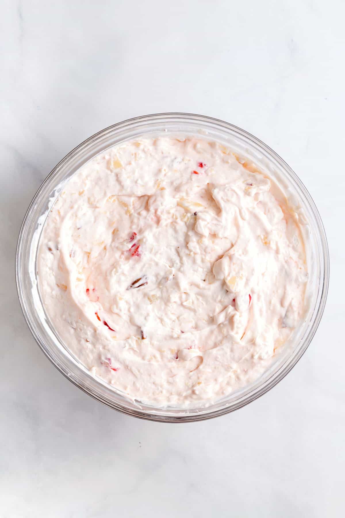 cool whip, cream cheese, condensed milk and chopped cherries, pecans and shredded coconut mixed together in a large glass bowl