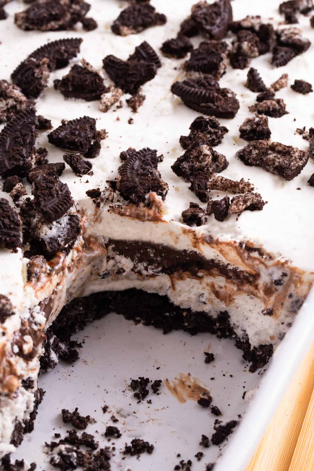close up image of a slice taken out of the oreo ice cream cake 9x13 baking dish to show the cross section layers