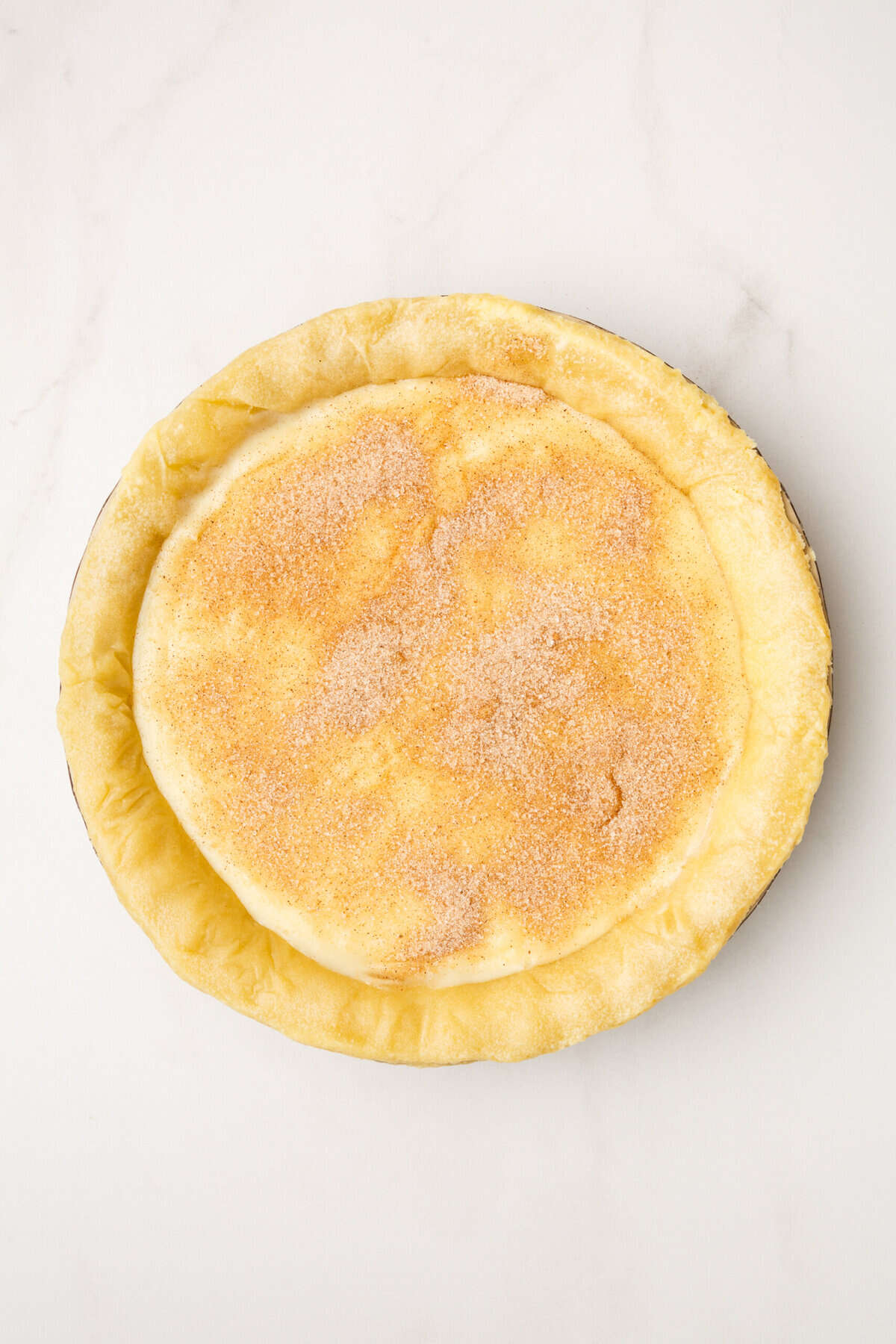 par baked pie crust with amish sugar cream pie filling topped with brown sugar and cinnamon.