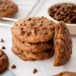 A stack of coffee cookies with one missing a bite laid against it.