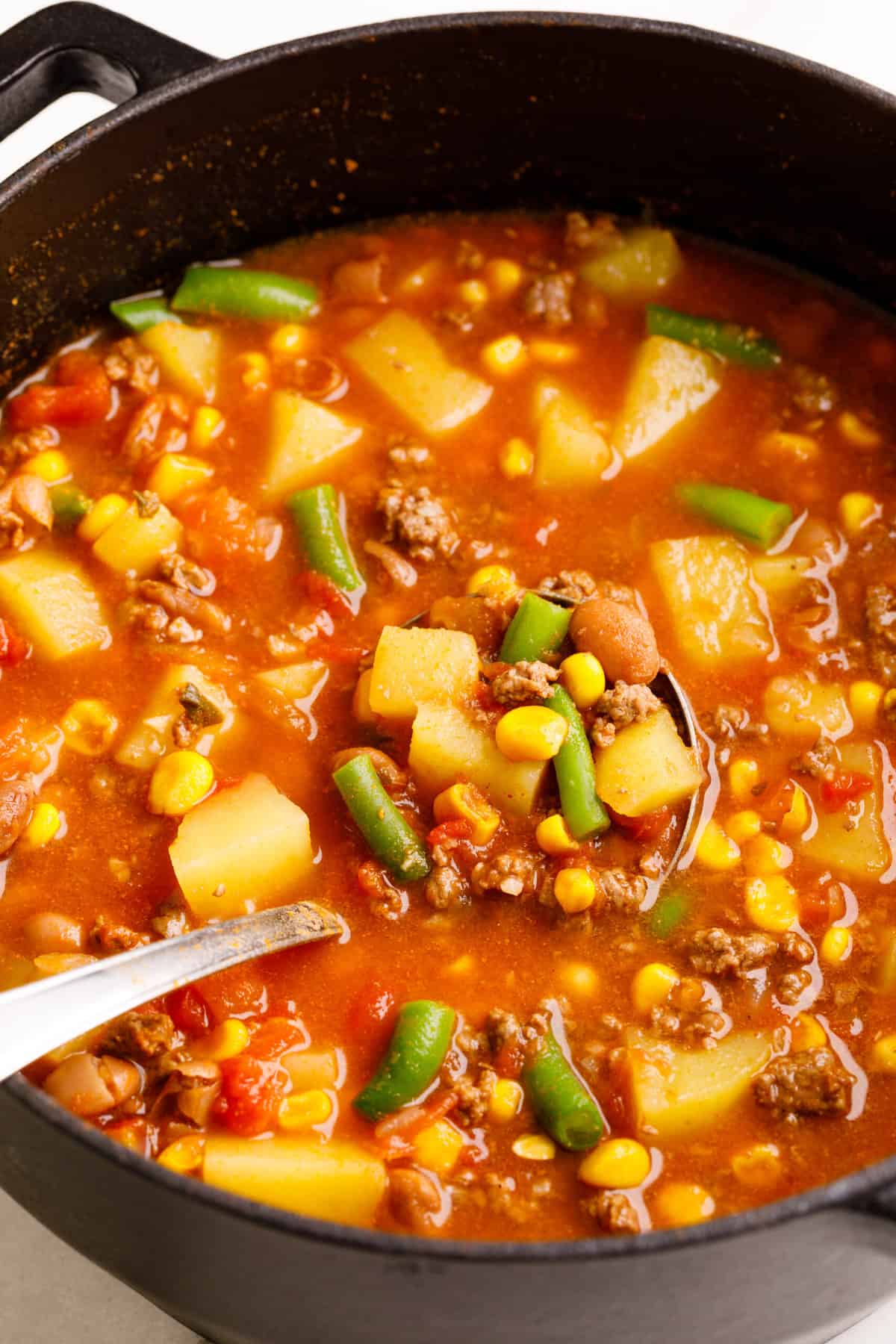 close up image of cowboy soup and a ladle full of soup
