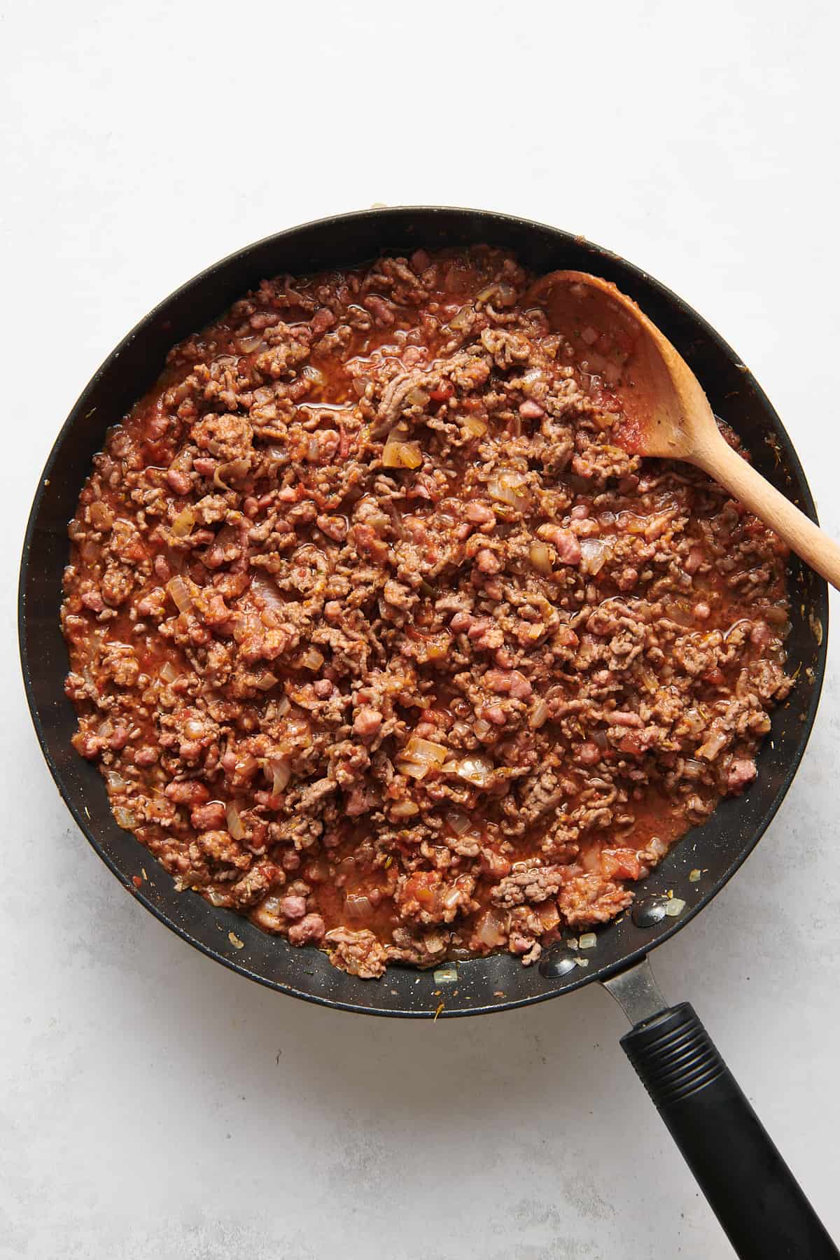 large skillet with cooked ground beef and sausage, onion and garlic, and marinara sauce