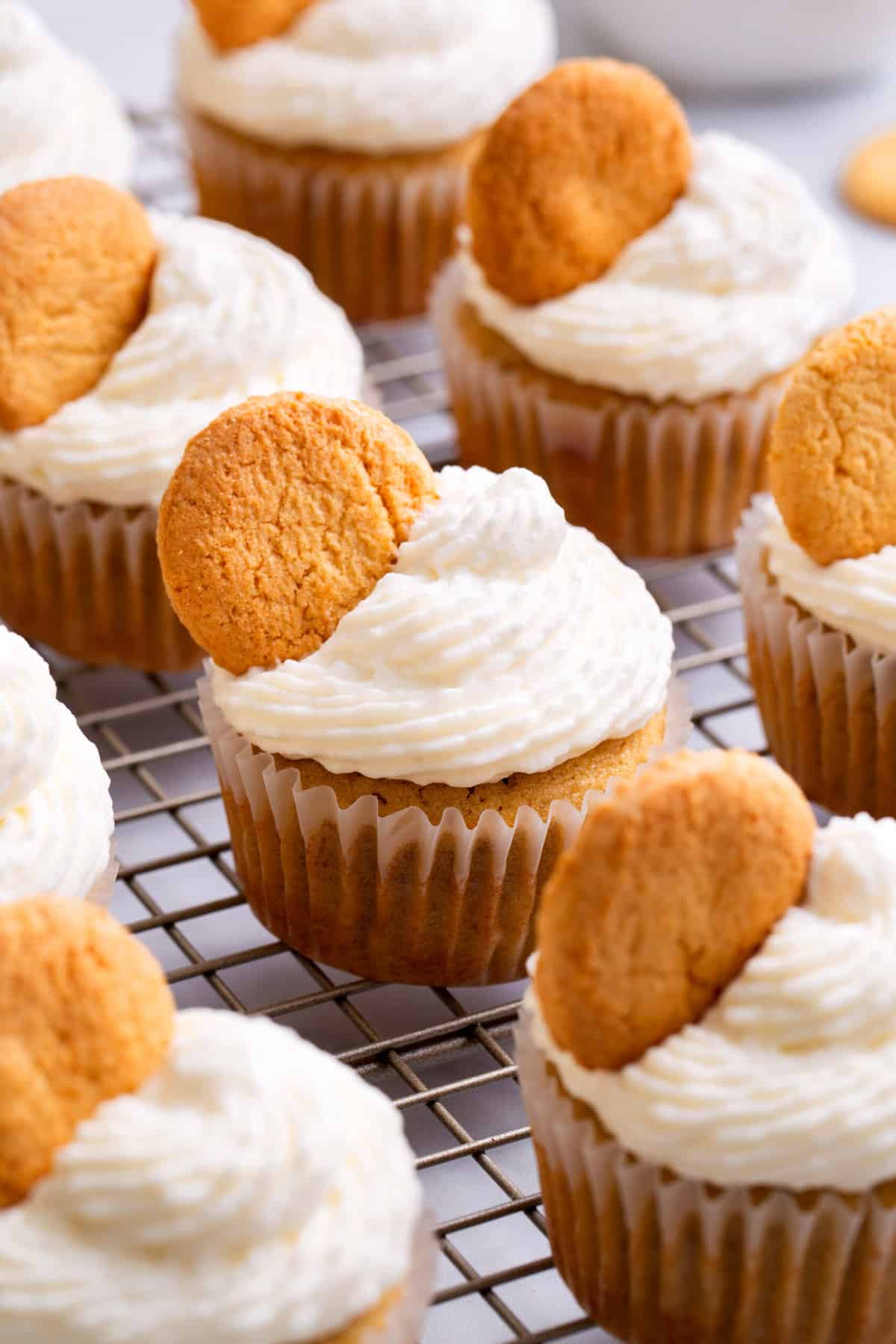 close up image of banana pudding cupcakes sitting on a cooling rack.
