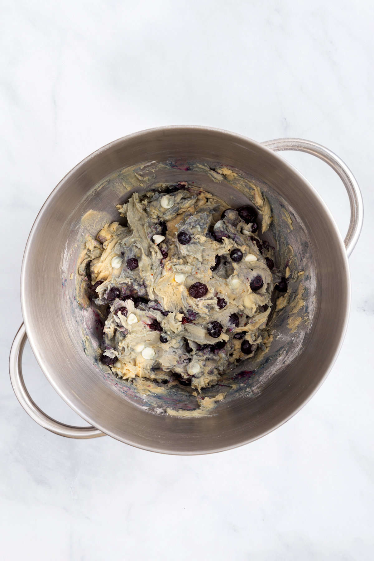stainless steel mixing bowl with blueberry cookie dough batter.