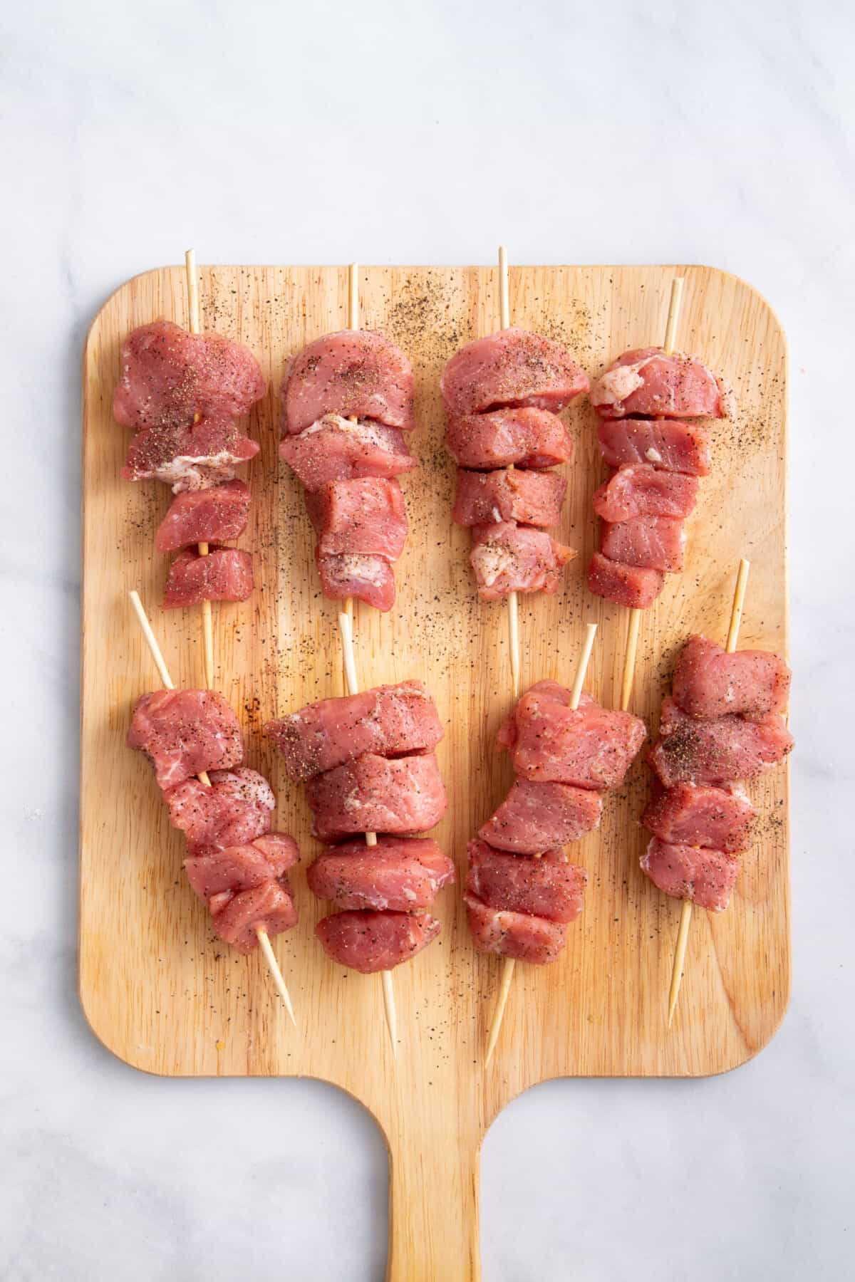 Pork threaded onto wooden skewers.