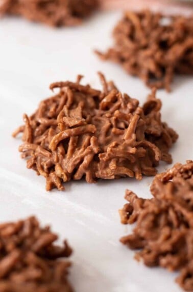 Chocolate peanut butter haystack cookies on parchment paper.