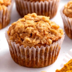 A pumpkin apple muffin in a paper liner.