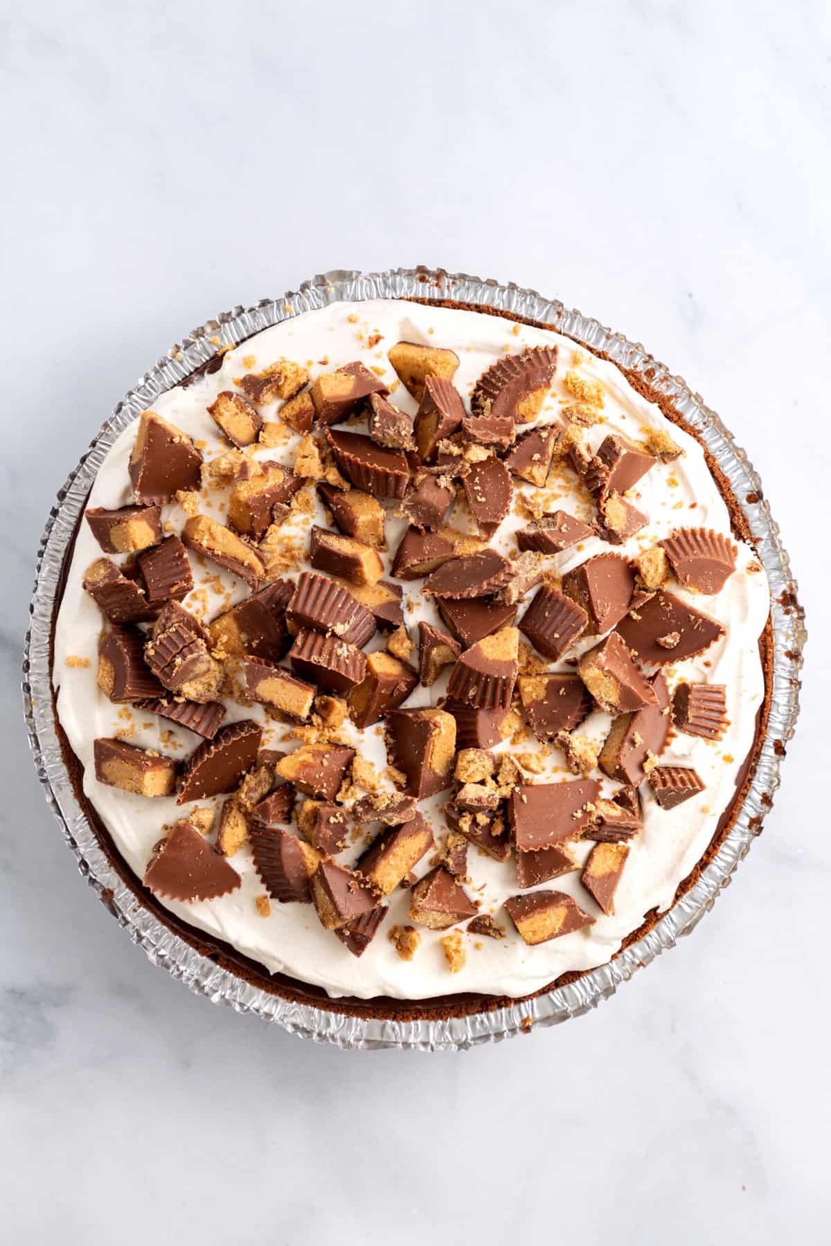 store-bought chocolate pie crust with peanut butter filling and chocolate ganache topped with whipped topping and chopped peanut butter cups.