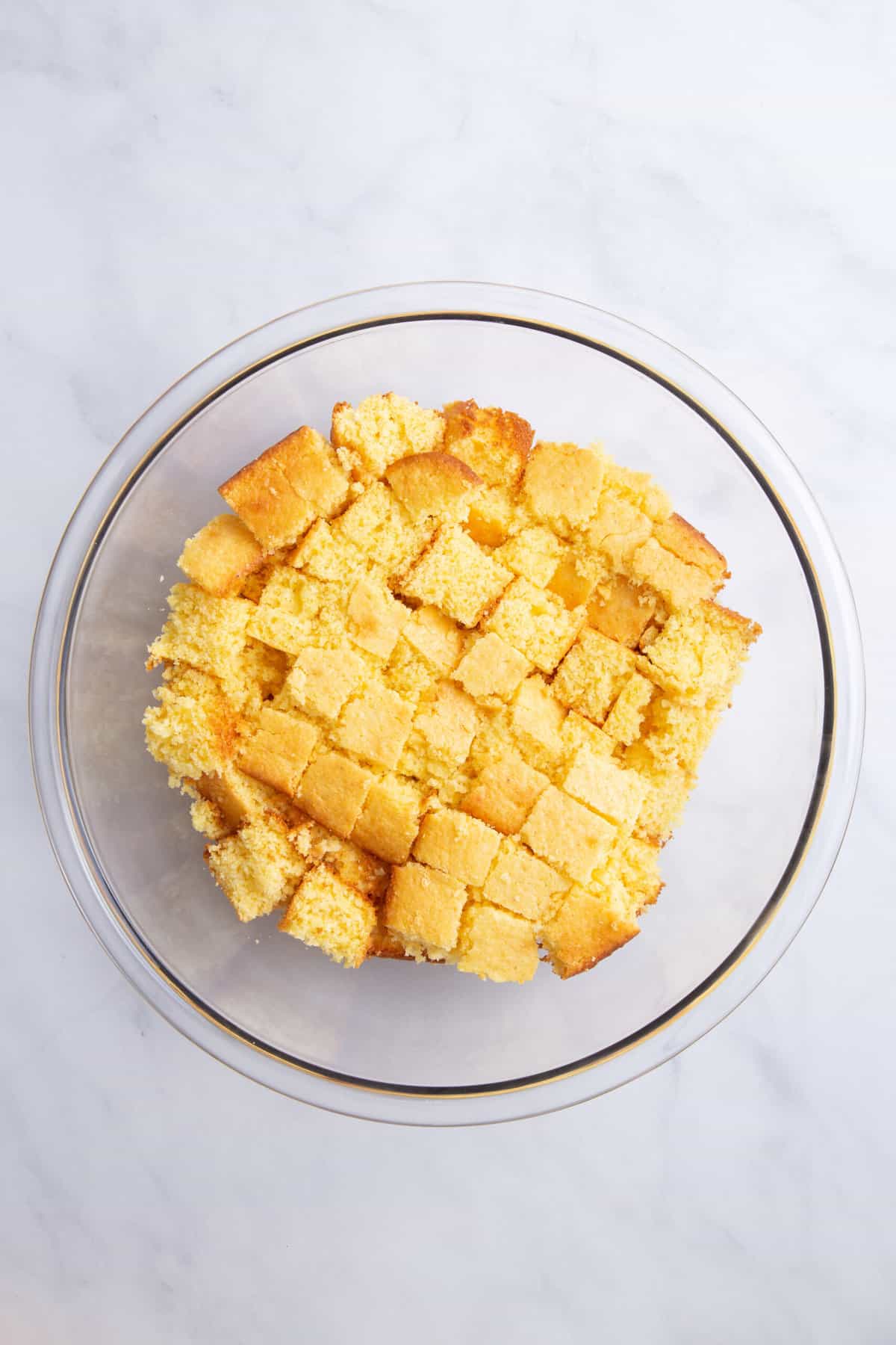 large glass bowl of cubed homemade cornbread.