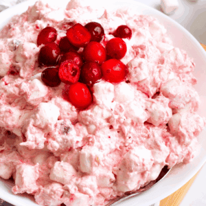A bowl of cranberry fluff topped with whole cranberries.
